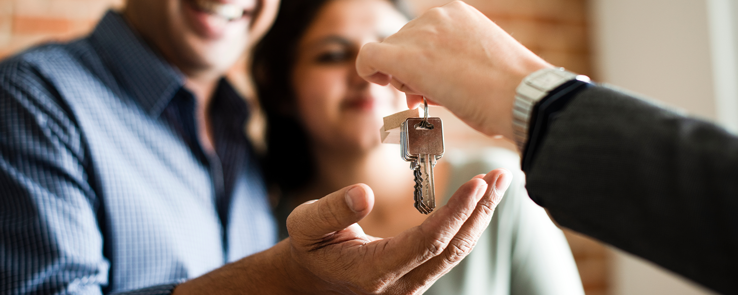 Agent giving key to couple