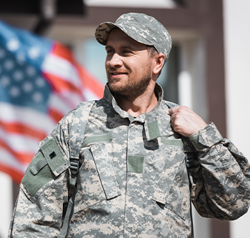 Soldier standing in front of American flag