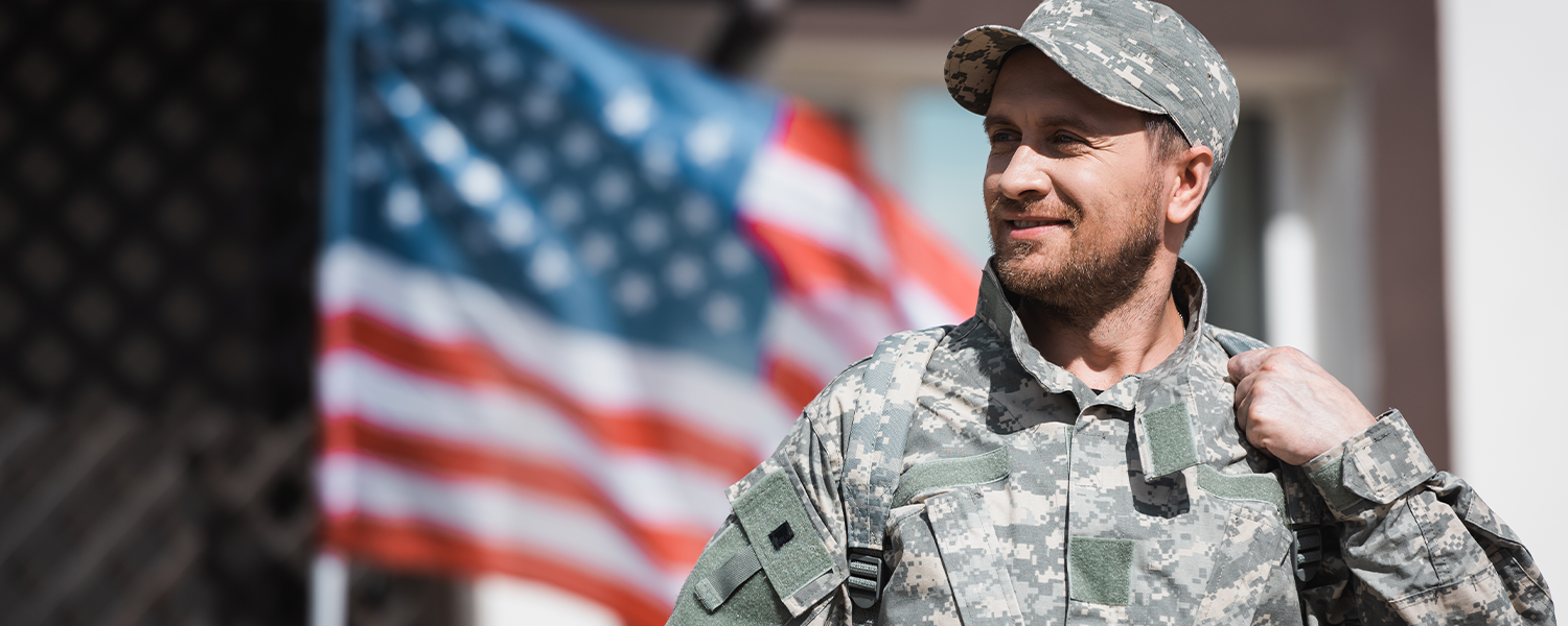 Soldier standing in front of American flag